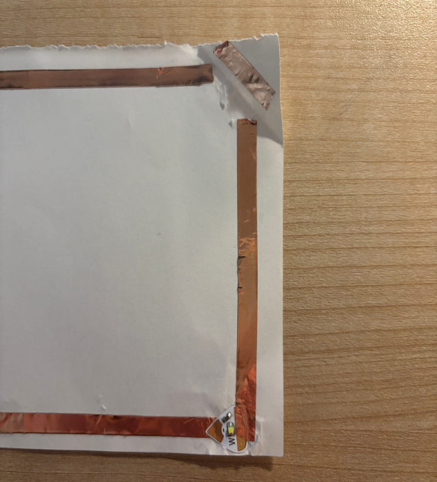 A partial view of a square-shaped paper circuit.