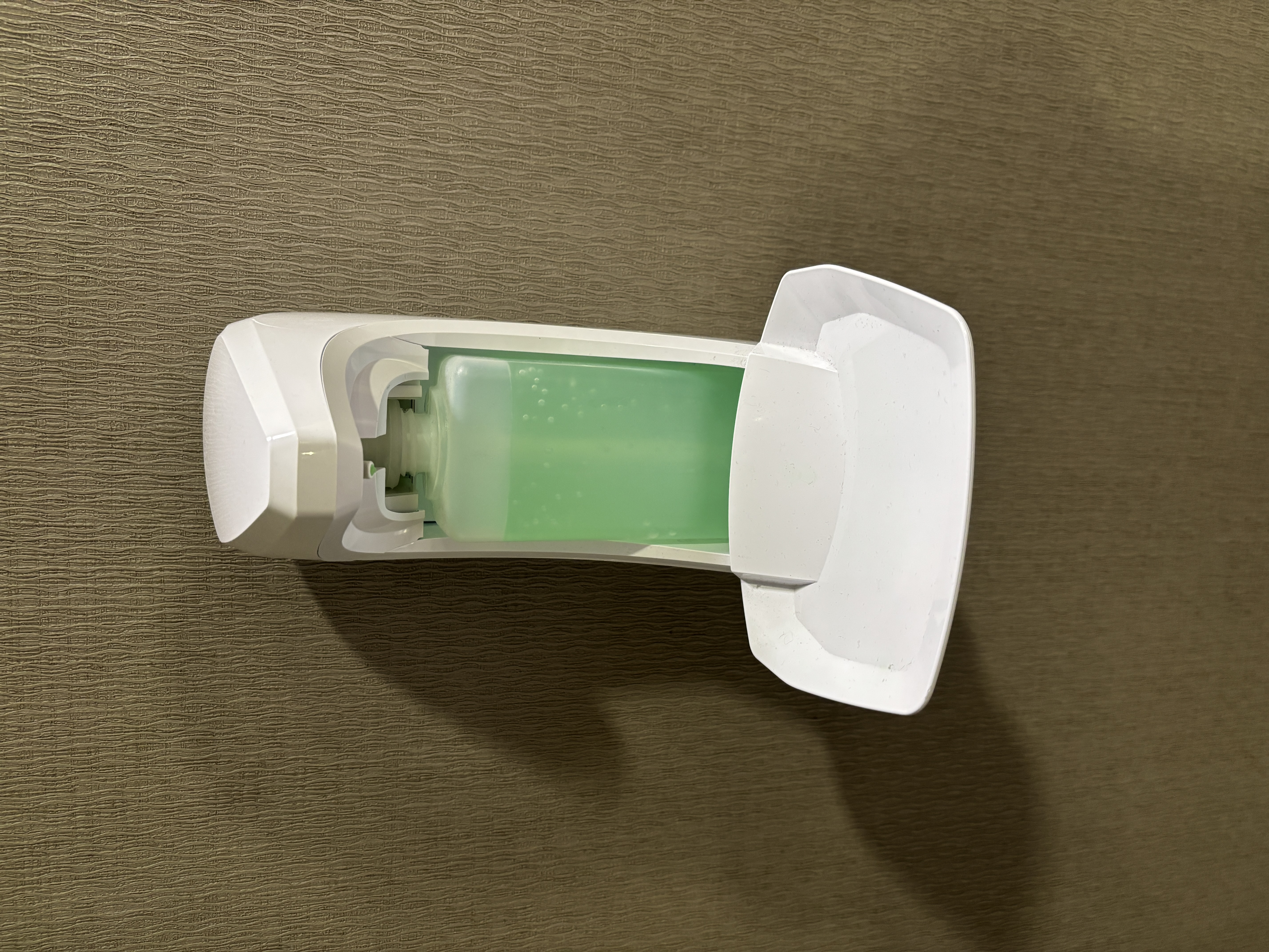 Automatic soap dispenser that makes a mechanical whirring sound when triggered.